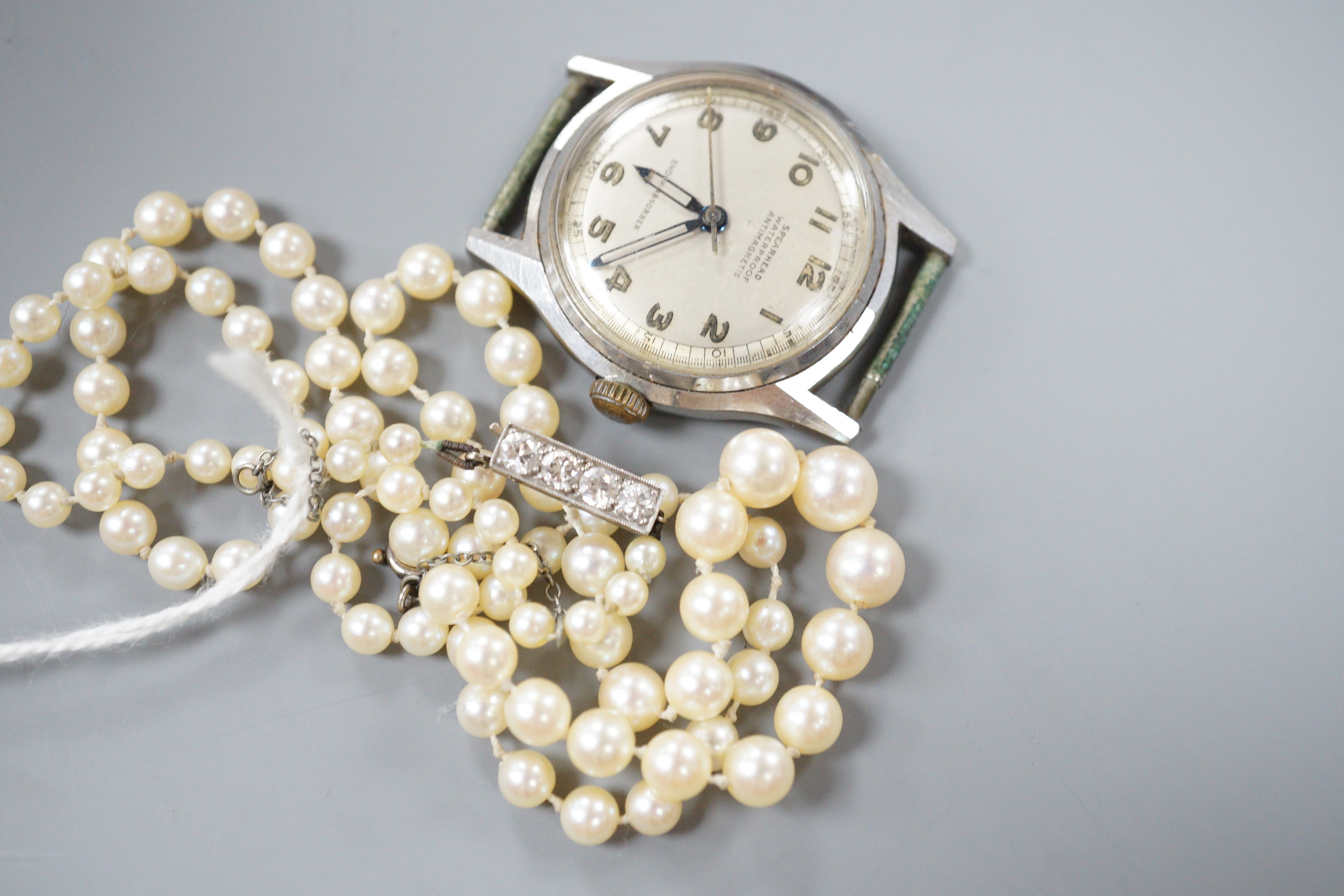 A single strand graduated cultured pearl necklace, with four stone diamond set white metal clasp, 50cm, gross weight 14.4 grams (pearls have not been tested), together with a gentleman's stainless steel Spearhead manual